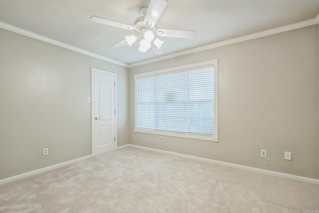 carpeted spare room featuring crown molding and ceiling fan