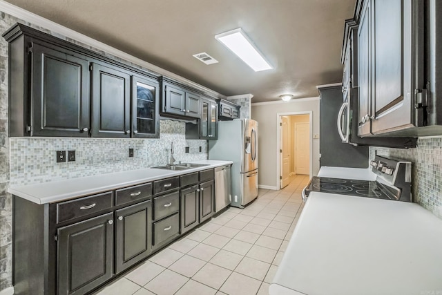 kitchen featuring backsplash, light tile patterned floors, ornamental molding, sink, and stainless steel appliances