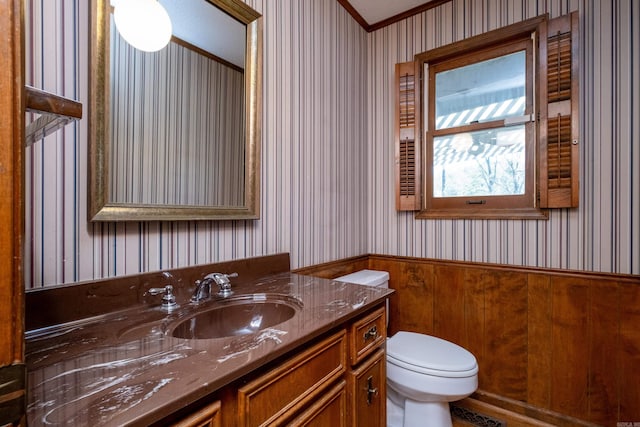 bathroom with vanity, toilet, and ornamental molding