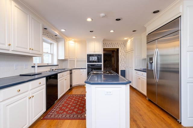 kitchen with light hardwood / wood-style floors, black appliances, a center island, and white cabinets