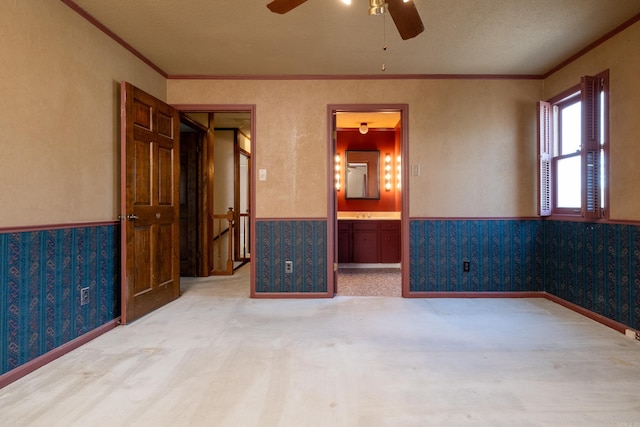 carpeted spare room with ornamental molding, a textured ceiling, and ceiling fan