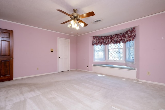 carpeted spare room with crown molding, a textured ceiling, and ceiling fan