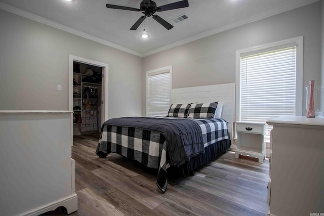 bedroom featuring dark hardwood / wood-style flooring, ornamental molding, and ceiling fan