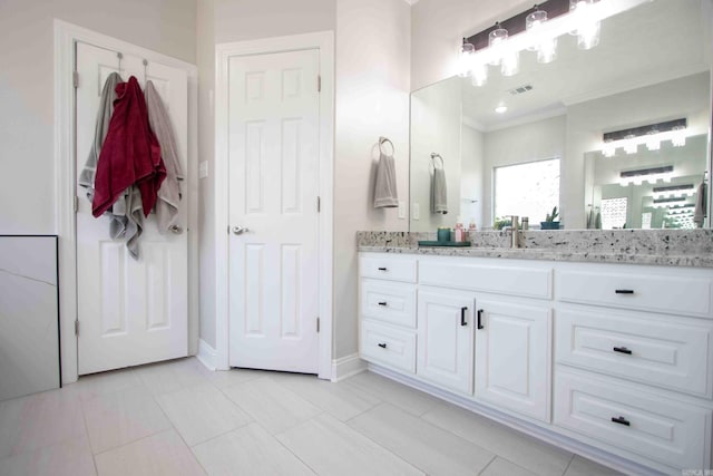 bathroom featuring vanity, ornamental molding, and tile patterned floors