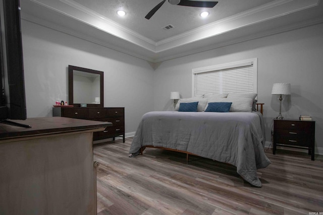 bedroom featuring ornamental molding, wood-type flooring, and ceiling fan