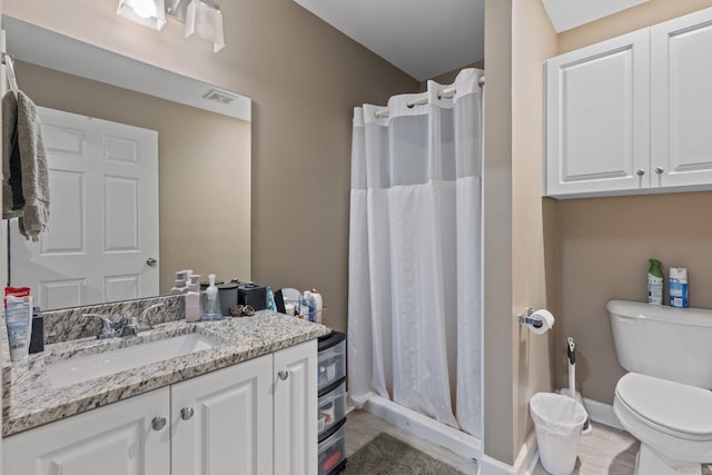 full bathroom featuring visible vents, baseboards, toilet, a shower stall, and vanity