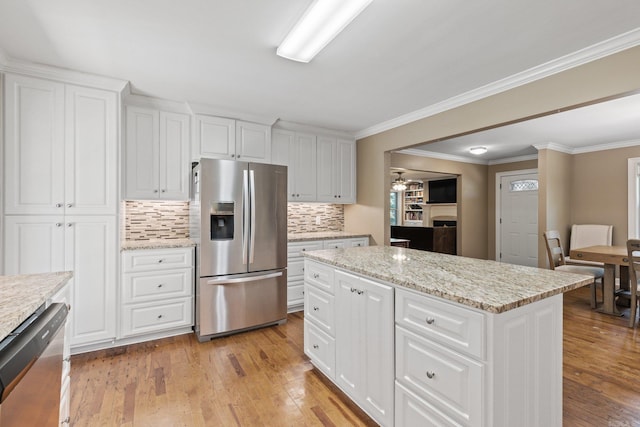 kitchen with white cabinets, backsplash, light wood-style flooring, and appliances with stainless steel finishes