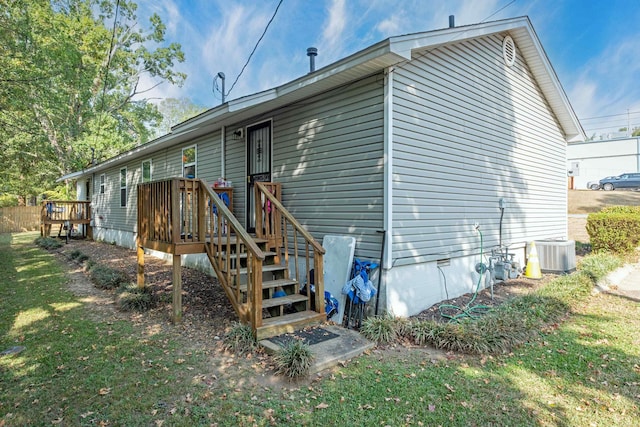 rear view of property featuring a yard and cooling unit