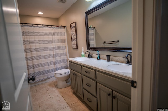 bathroom with vanity, tile patterned flooring, toilet, and walk in shower