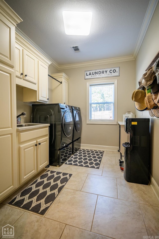 clothes washing area featuring light tile patterned floors, sink, independent washer and dryer, crown molding, and cabinets