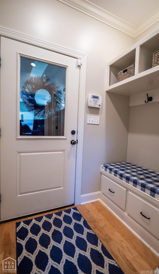 mudroom with wood-type flooring and ornamental molding