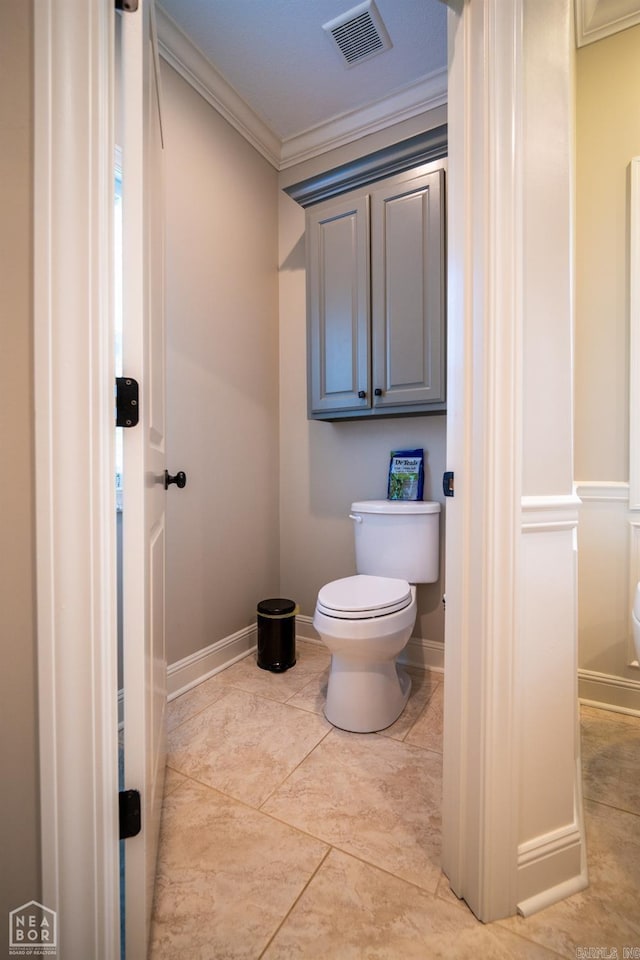 bathroom featuring ornamental molding, toilet, and tile patterned flooring