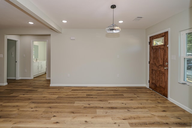 foyer entrance featuring beamed ceiling and wood-type flooring