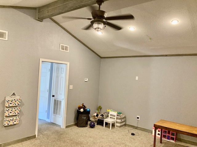 rec room with ceiling fan, a textured ceiling, crown molding, lofted ceiling with beams, and light colored carpet