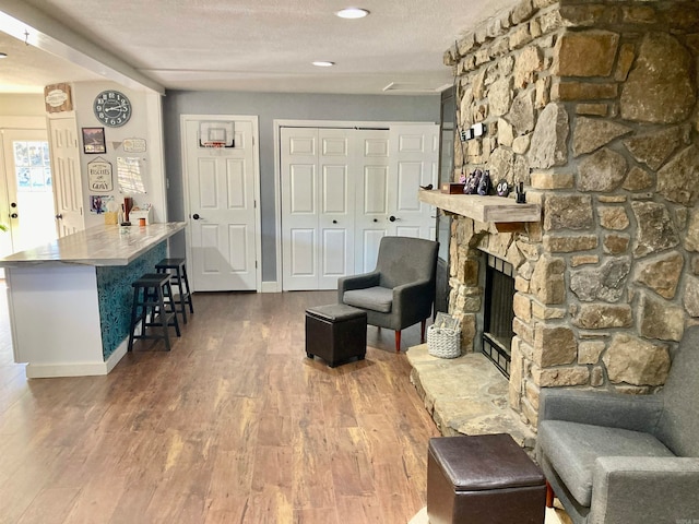 living room with hardwood / wood-style floors, a fireplace, and a textured ceiling