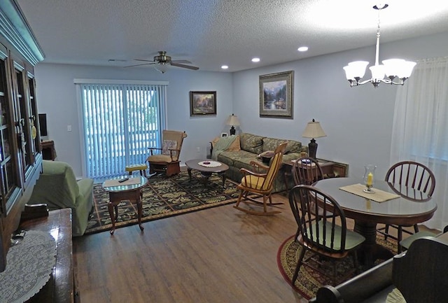 living room with a textured ceiling, ceiling fan with notable chandelier, and dark hardwood / wood-style flooring