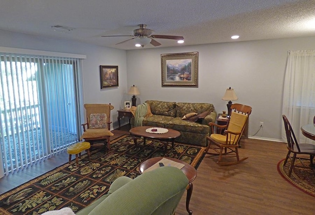 living room featuring a textured ceiling, hardwood / wood-style flooring, and ceiling fan