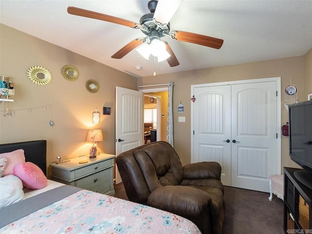 bedroom with dark colored carpet, ceiling fan, and a closet