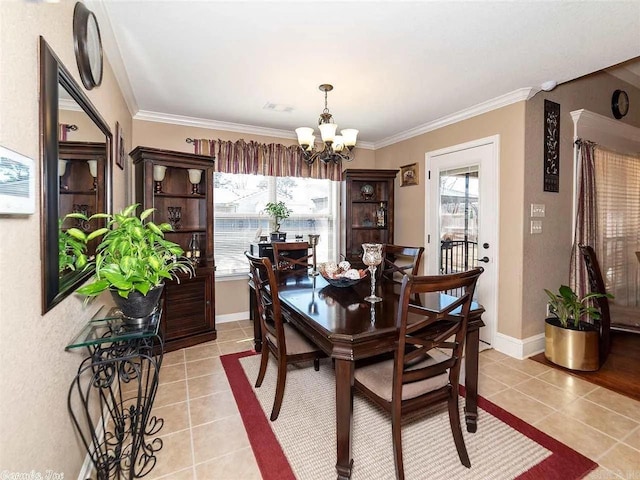 tiled dining space featuring an inviting chandelier and crown molding