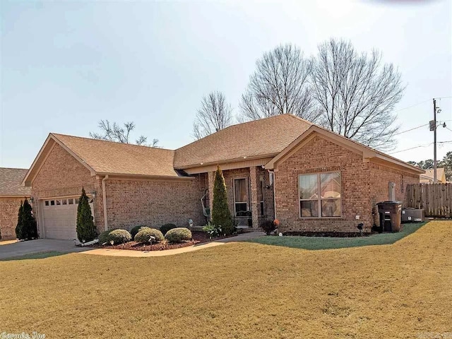 ranch-style house featuring a garage and a front lawn