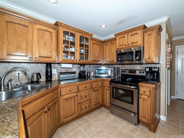 kitchen with sink, tasteful backsplash, crown molding, light tile patterned floors, and appliances with stainless steel finishes