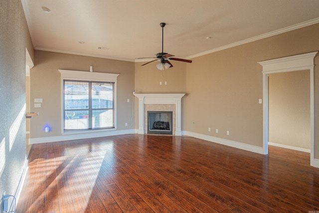 unfurnished living room featuring a tile fireplace, ornamental molding, ceiling fan, and dark wood-type flooring