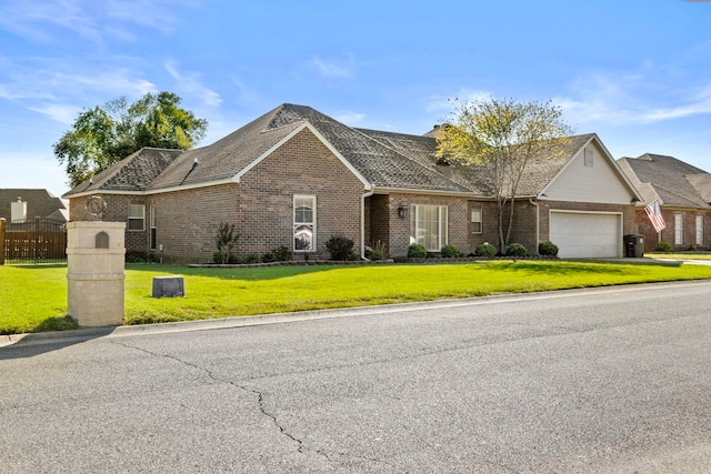 single story home featuring a front lawn and a garage