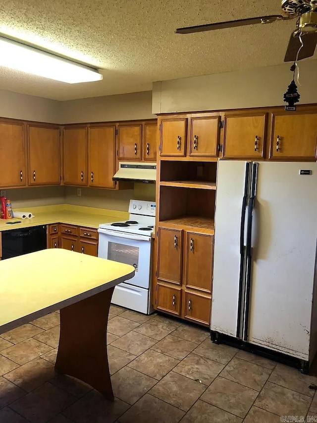 kitchen with dark tile patterned floors, a textured ceiling, white appliances, and ceiling fan