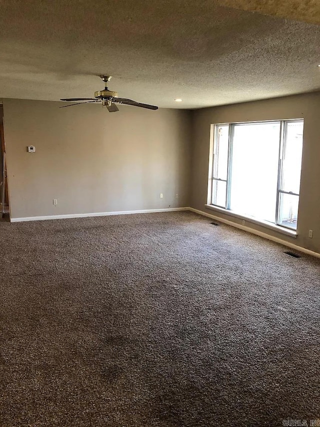 carpeted empty room with a textured ceiling and ceiling fan