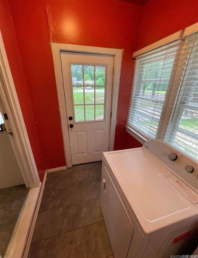 laundry area with washer / dryer and dark tile patterned floors