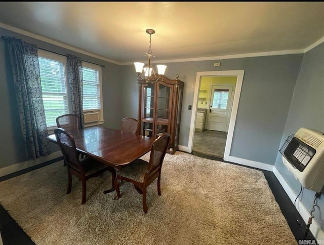 dining space with a notable chandelier, carpet floors, heating unit, and crown molding