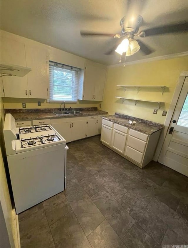 kitchen featuring white cabinets, ceiling fan, white stove, ornamental molding, and sink