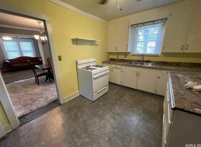 kitchen with white gas range oven, sink, a wealth of natural light, and white cabinets