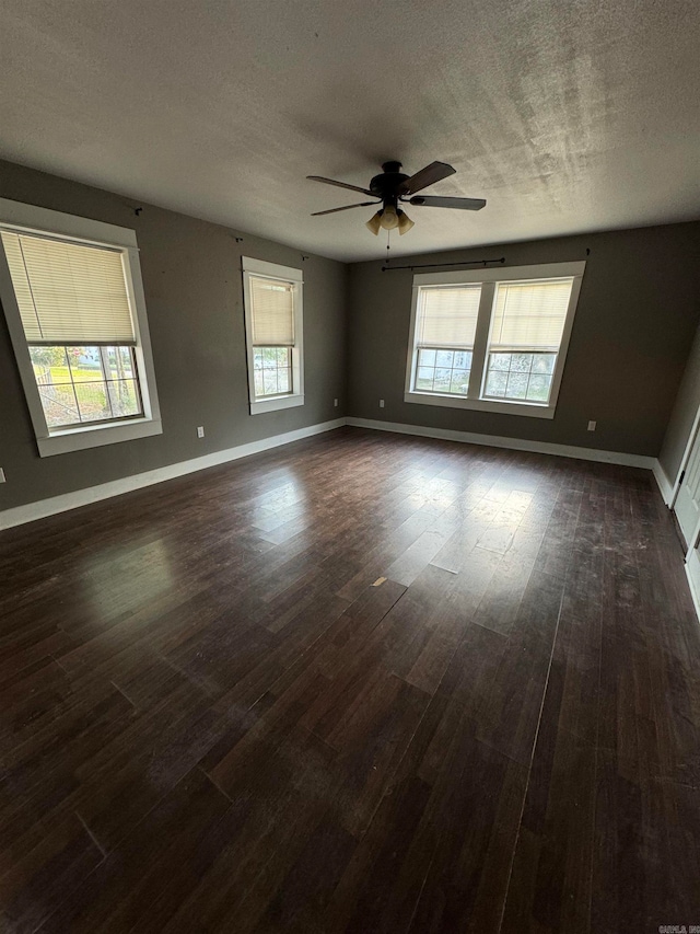 spare room with dark wood-type flooring, a textured ceiling, and ceiling fan