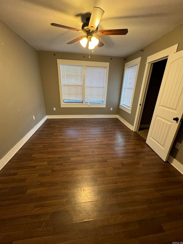 unfurnished bedroom featuring a textured ceiling, dark hardwood / wood-style floors, and ceiling fan