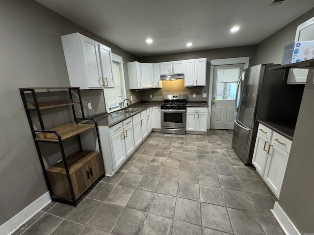 kitchen featuring appliances with stainless steel finishes, white cabinets, and sink