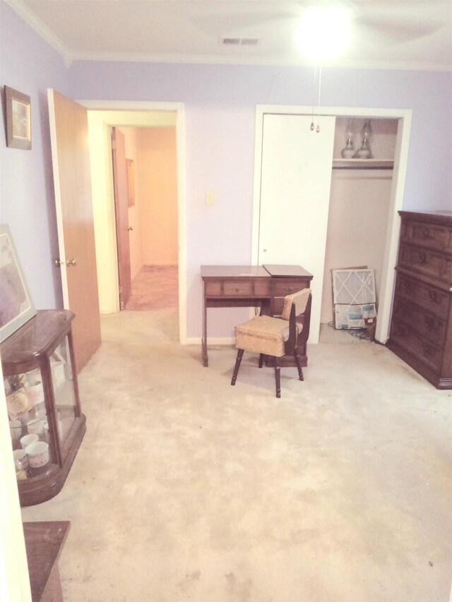 sitting room with ornamental molding and light colored carpet