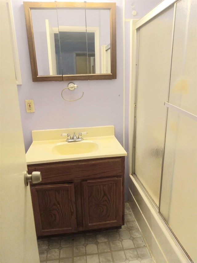 bathroom with vanity and combined bath / shower with glass door