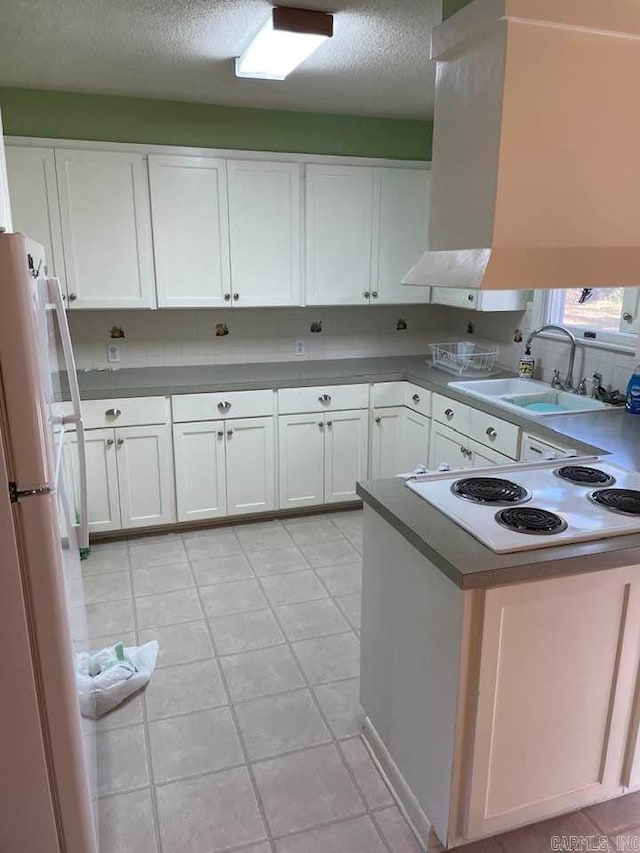 kitchen featuring white cabinetry, sink, a textured ceiling, white appliances, and light tile patterned floors