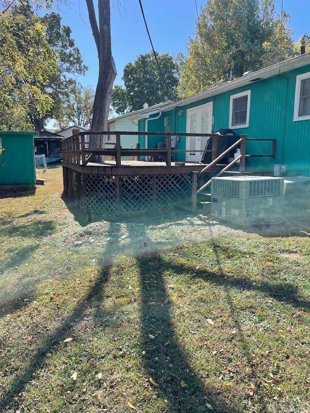 rear view of property with a lawn and a deck