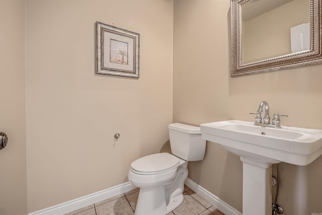 bathroom with toilet, tile patterned floors, and sink