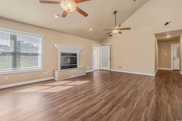 unfurnished living room featuring a fireplace, wood-type flooring, high vaulted ceiling, and ceiling fan