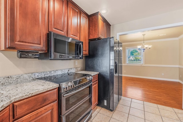 kitchen with stainless steel appliances, ornamental molding, light stone countertops, light wood-type flooring, and a chandelier