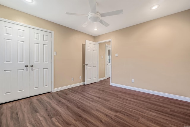 unfurnished bedroom with dark wood-type flooring, a closet, and ceiling fan