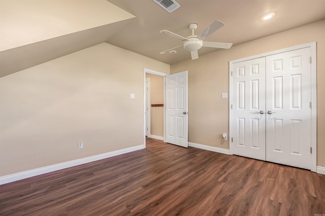 unfurnished bedroom featuring a closet, dark wood-type flooring, vaulted ceiling, and ceiling fan