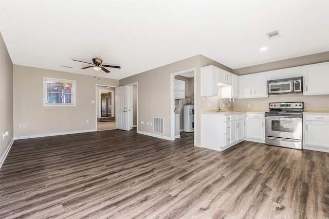 kitchen with stainless steel appliances, dark hardwood / wood-style flooring, water heater, and white cabinets