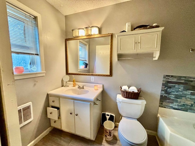 bathroom featuring vanity, a textured ceiling, and toilet