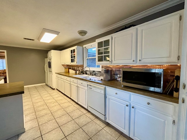 kitchen with backsplash, ornamental molding, dishwasher, and white cabinets