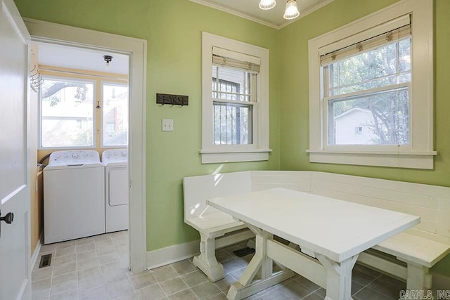 clothes washing area with breakfast area, plenty of natural light, and washer and clothes dryer