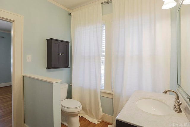 bathroom with ornamental molding, hardwood / wood-style floors, vanity, and toilet